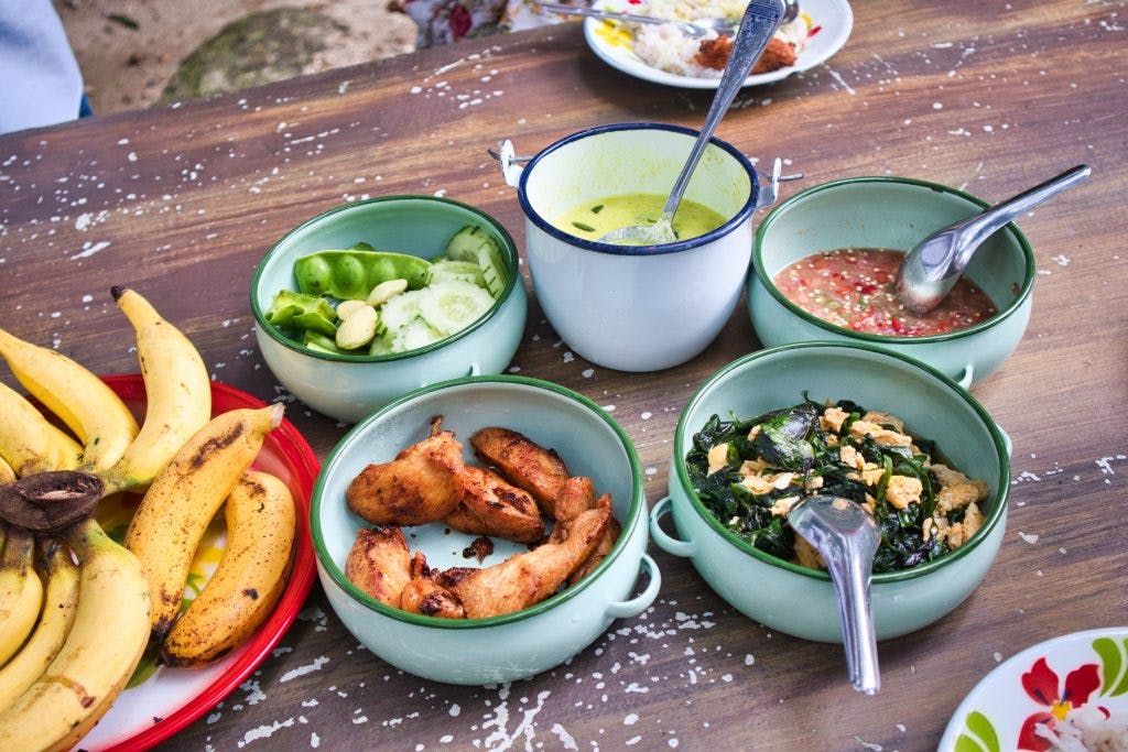 Traditional Thai dishes set up on a table in metal containers. 