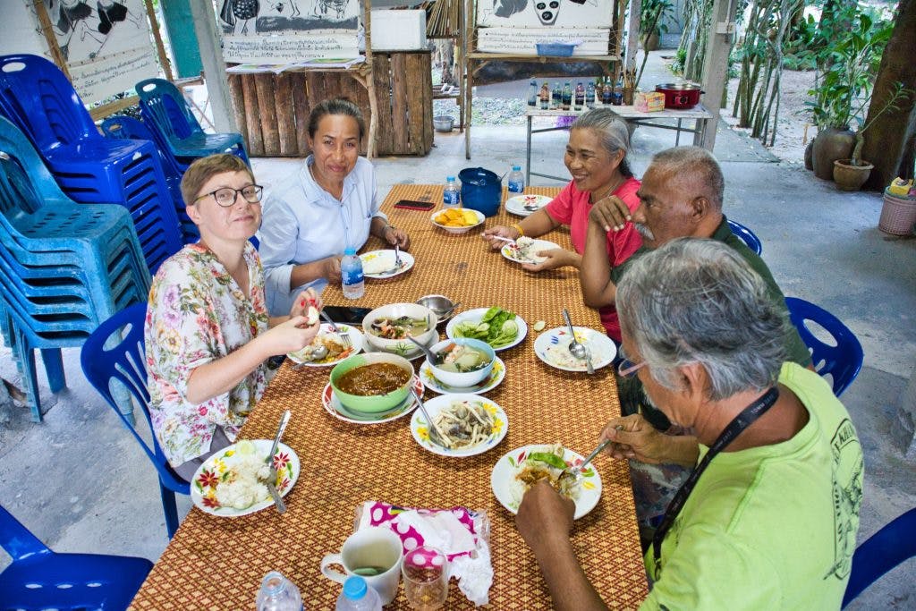 turystka w towarzystwie tajów je tajskie potrawy na tajskiej wsi