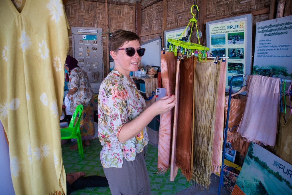 zachodnia turystka przegląda ubrania i szale wykonane przez lokalną ludność na koh klang 