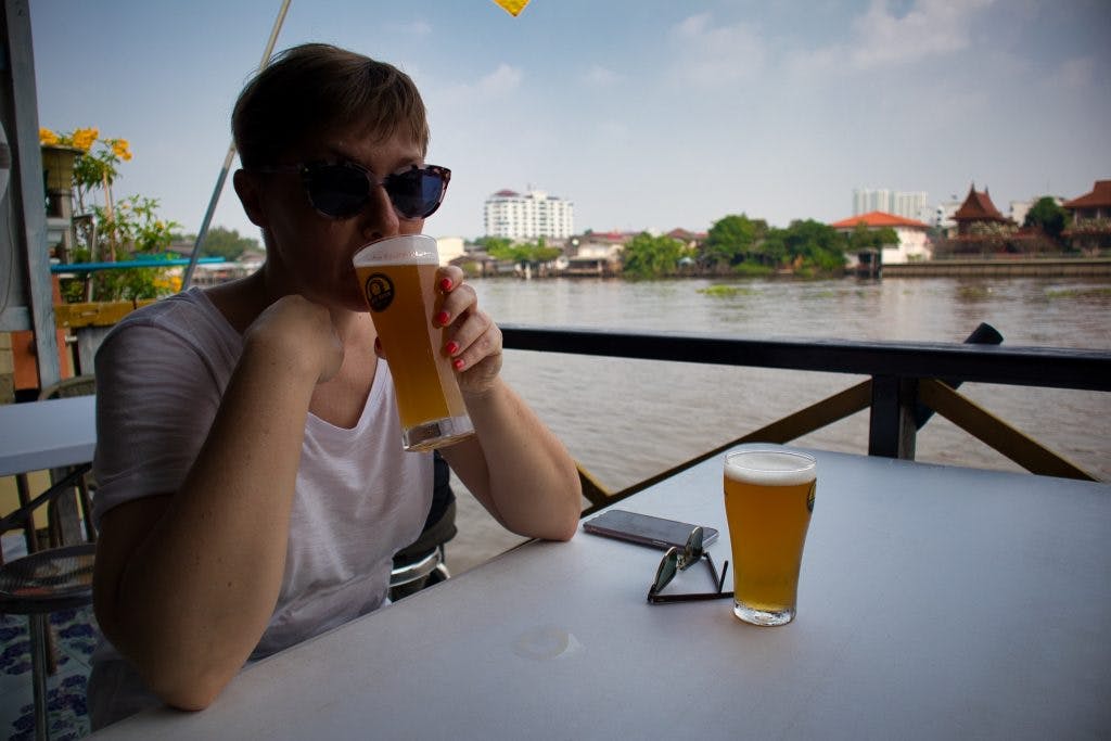 a woman drinks a kraft beer at Chit Beer, on Koh Kret, Bangkok. 