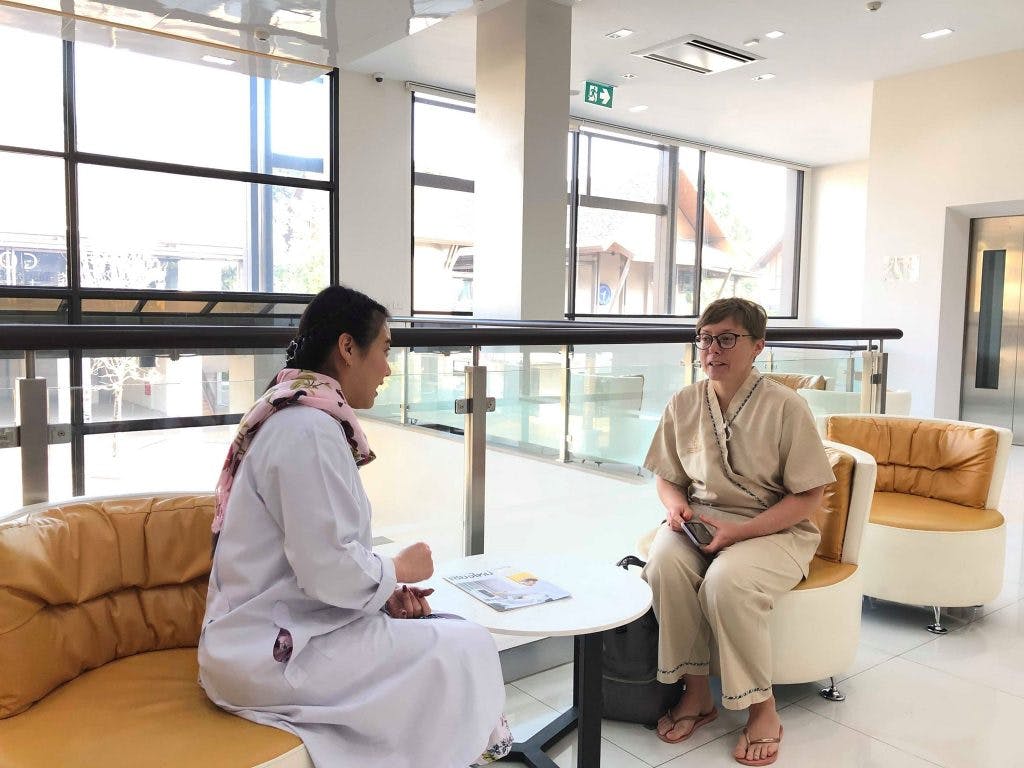 a foreign woman talking to a thai doctor at a ram hospital, chiang mai, thailand  