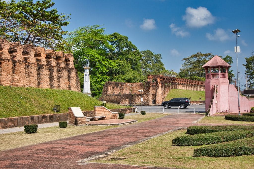 a city wall in nakhon si thammarat with a pink tower