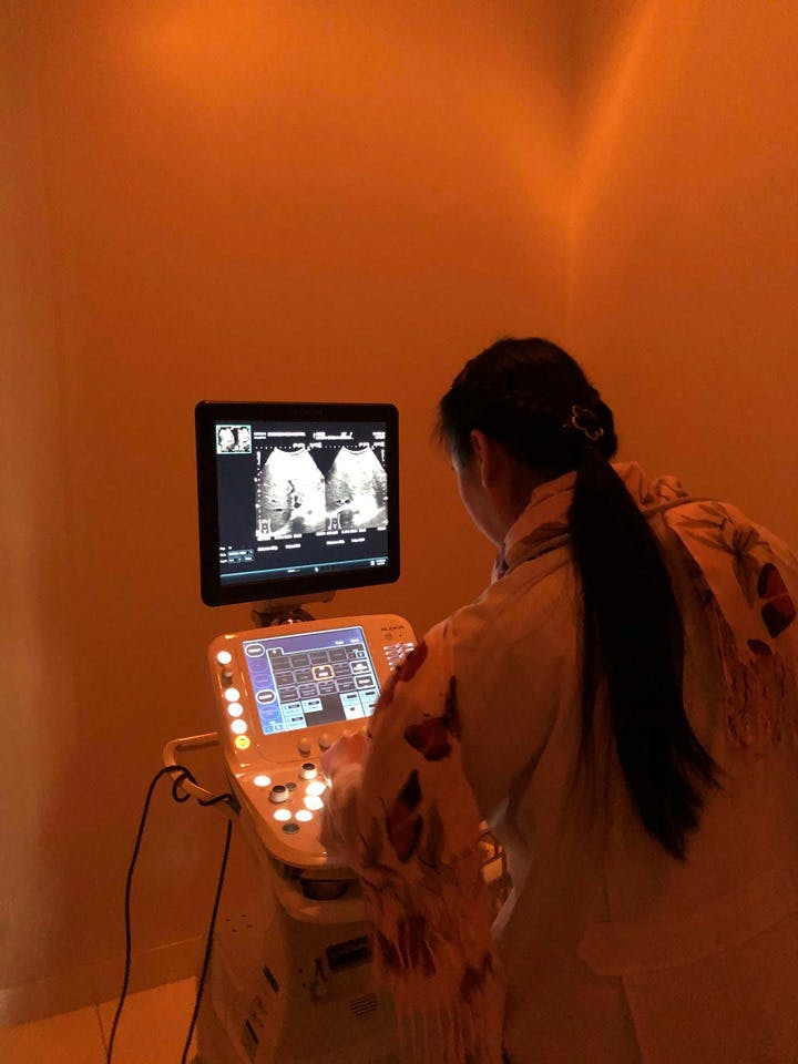 a thai doctor looks at the ultrasound monitor at the ram hospital in chiang mai. 