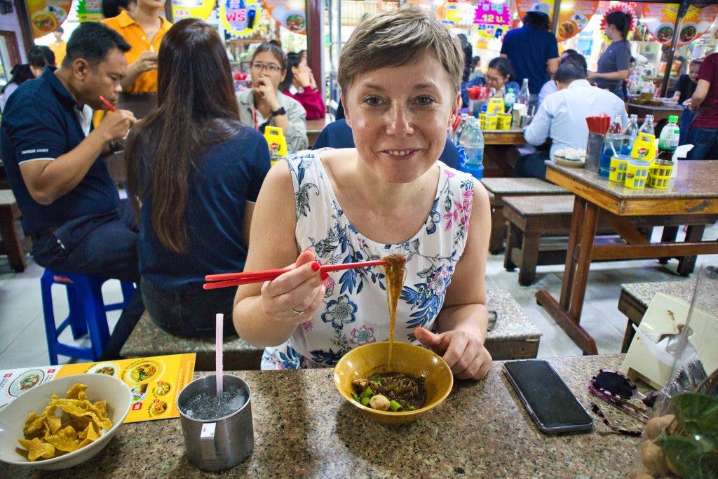 kobieta je boat noodles, lokalne jedzenie w bangkoku.