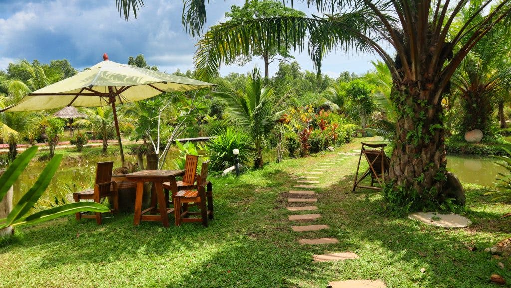 a beautiful garden with some lounge tables and chairs on koh lanta, koh lanta park life, thailand. 