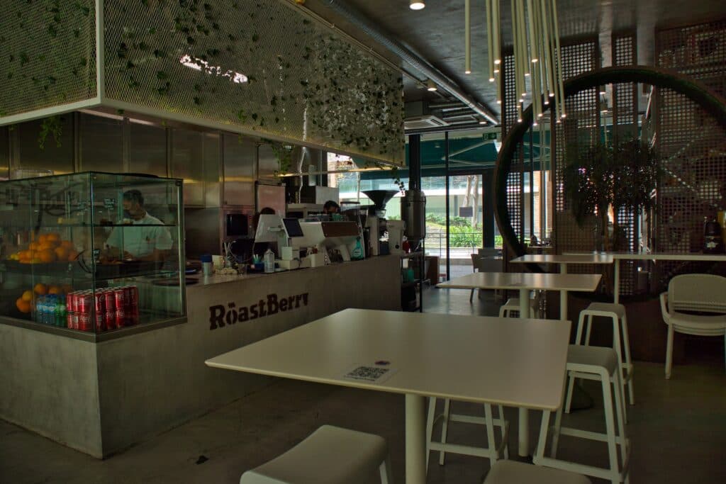 Metalowe stoliki i maszyny w środku w kawiarni w Lizbonie.