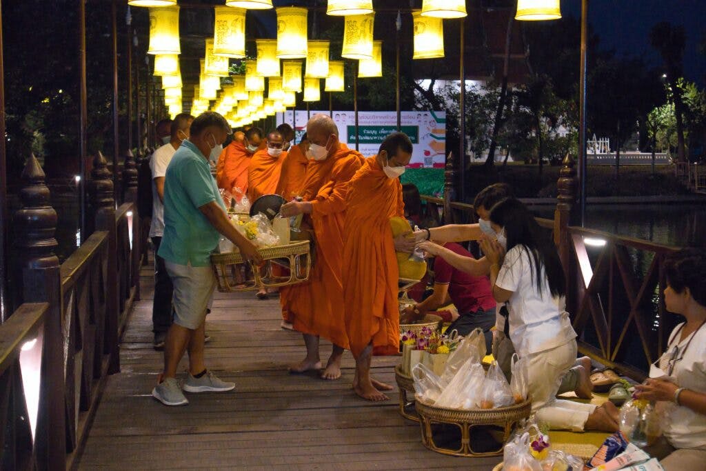 Thai people performing morning alms in Sukothai, Thailand. 