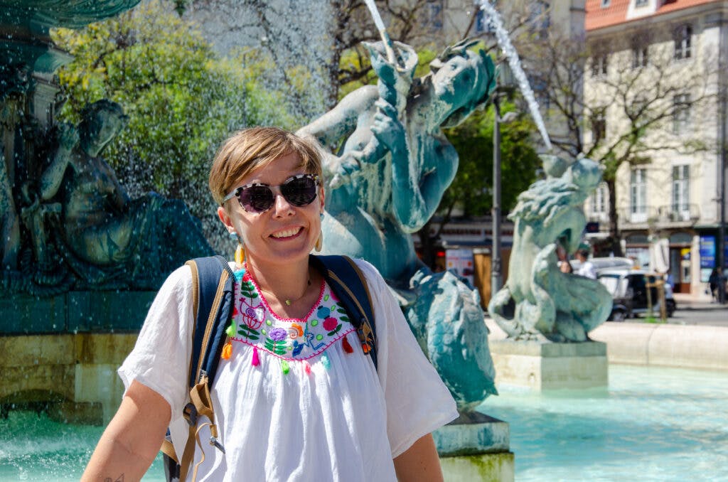 Dziewczyna na tle fontanny na placu w Lizbonie. 