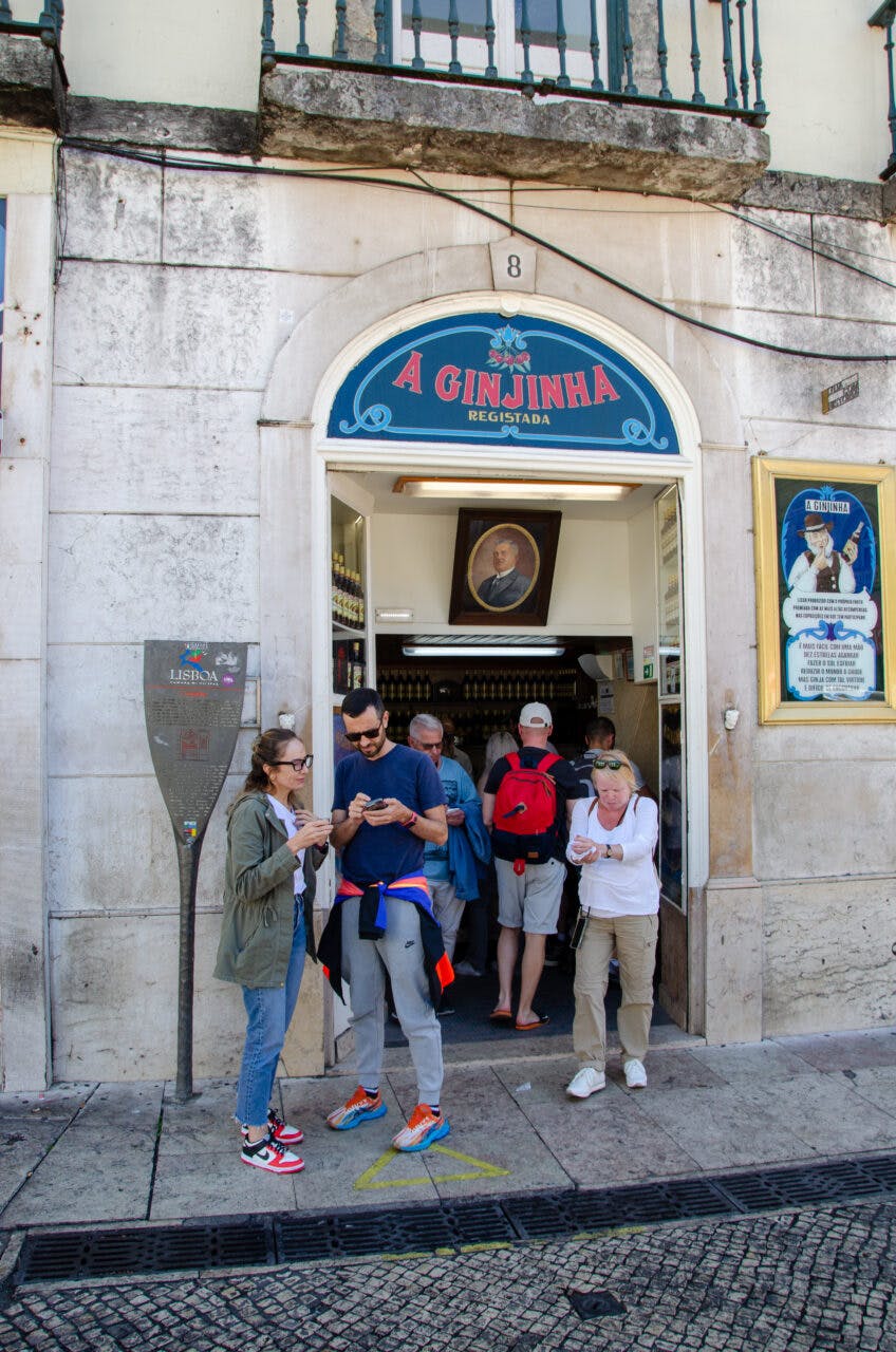 People standing outside of the ginjinha bar in Lisbon. 