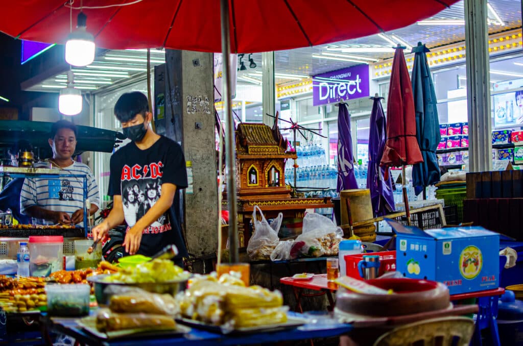 A young boy packing food at a night market in Chiang Mai.