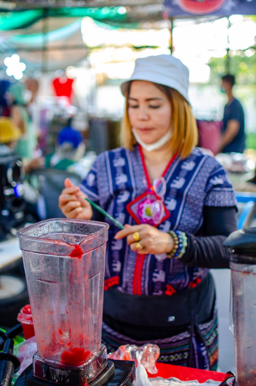 A Thai woman makes a smoothie out of strawberries. 