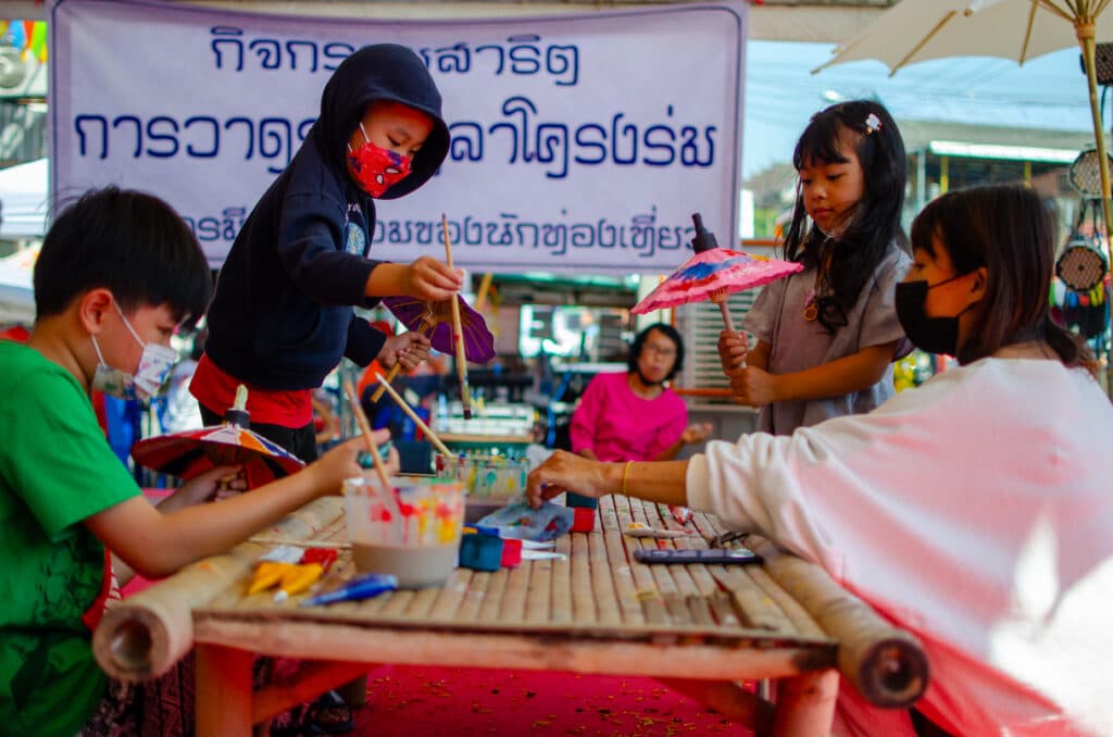 A group of children paint little umbrellas during the umbrella festival in Bo Sang near Chiang Mai.