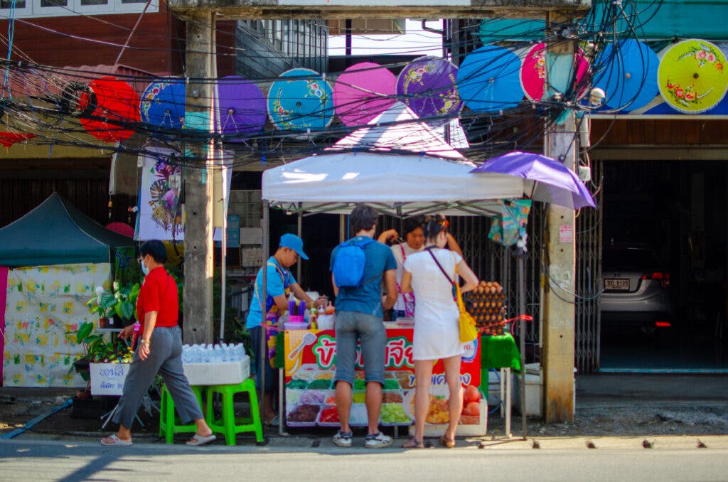 Para turystów kupuje deser na stoisku w wiosce niedaleko Chiang Mai. 