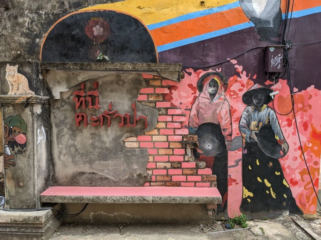 Grafitti na ścianie budynku w Ta Kuapa, przedstawiające 2 kobiety w chińskich strojach. 