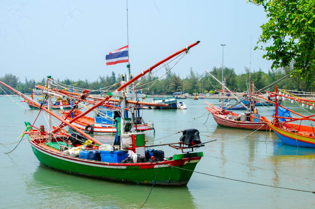 Kolorowe łodzie stoją w zatoce Phrachuap Khiri Khan. 