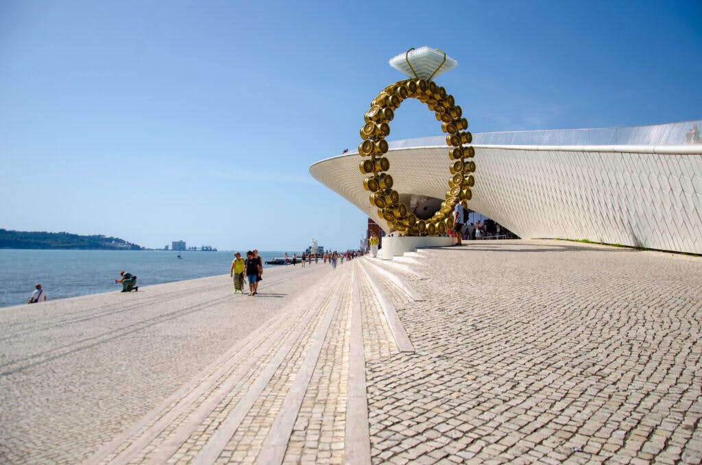 Wielki pierścionek przy muzeum maat w Lizbonie stoi nad rzeką w słoneczny dzień. 