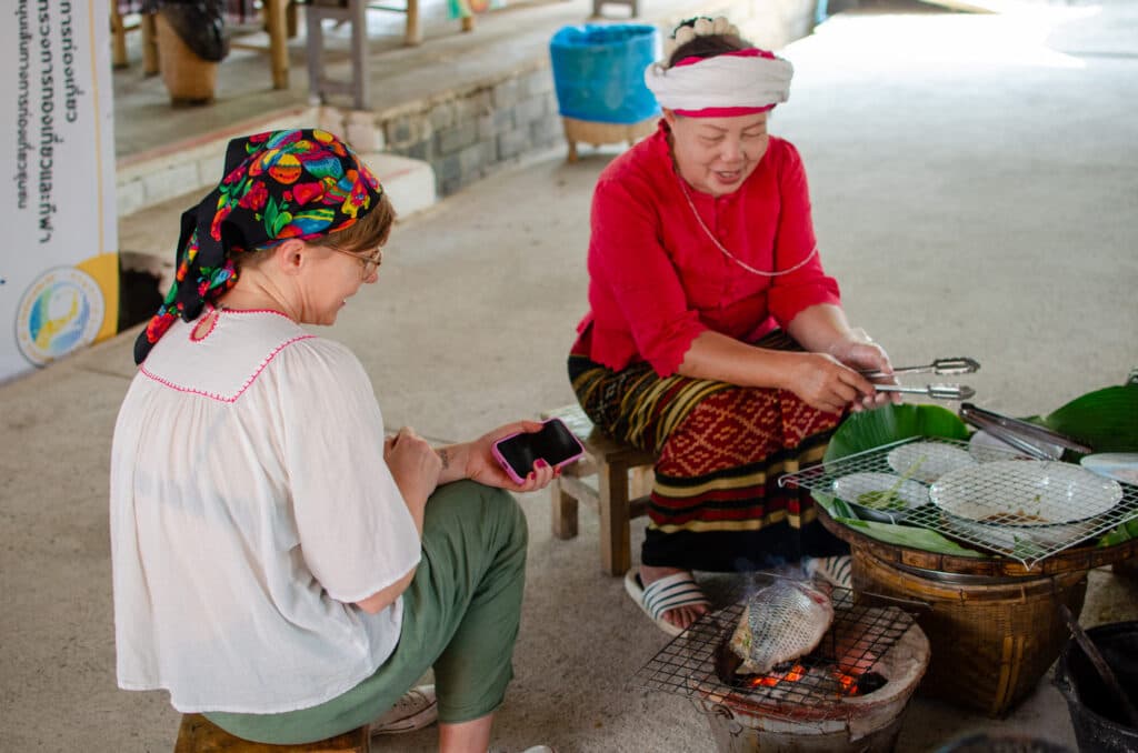 Women chatting over a grill.