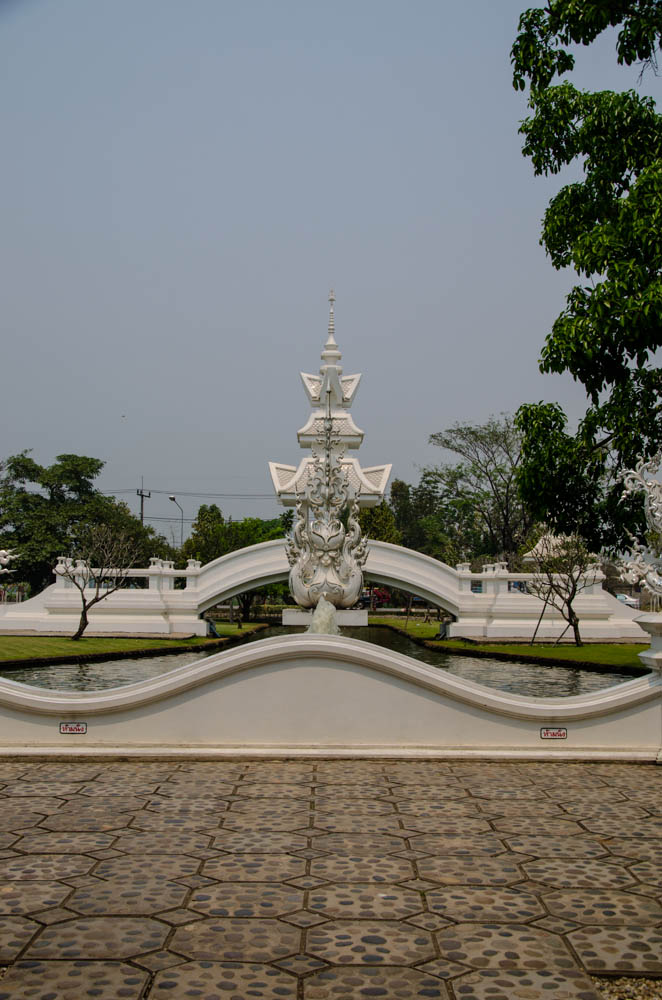 a white statue showing a dragon at white temple in chiang rai