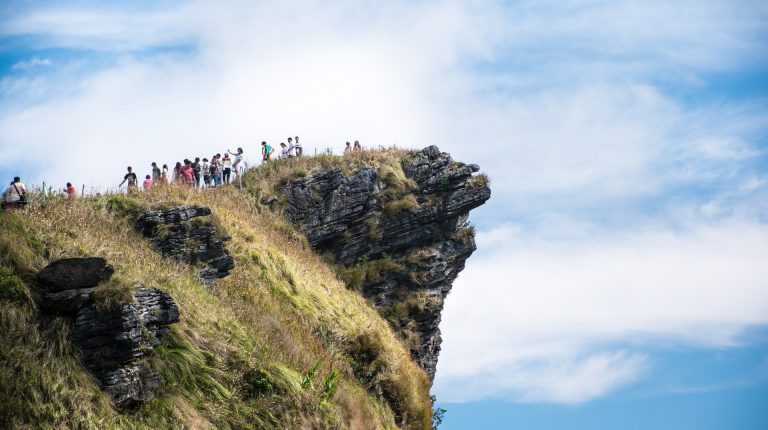 people standing on the edge of the phu chi fa mountain
