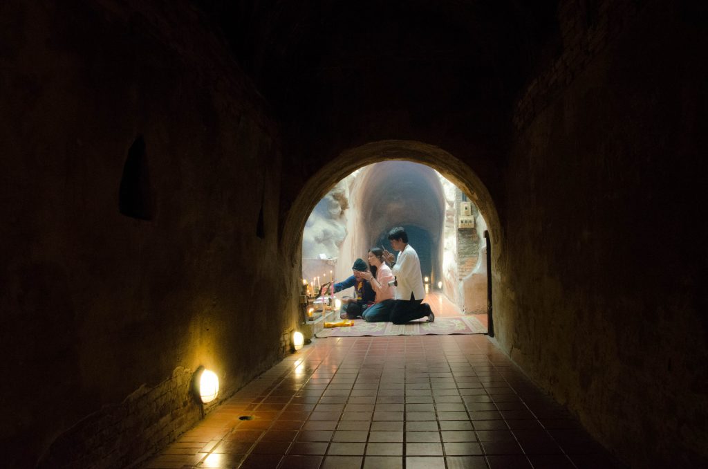 W tunelach, przy małych posągach Buddy, w oparach kadzideł wierni modlą się i medytują