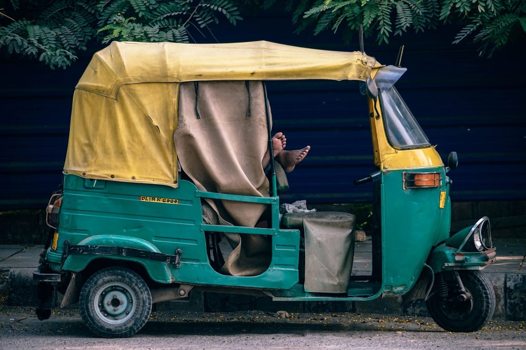 a driver sleeping in a tuk tuk