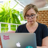 joanna horanin sits at a laptop in a green coffee shop