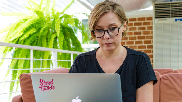 joanna horanin sits at a laptop in a green coffee shop