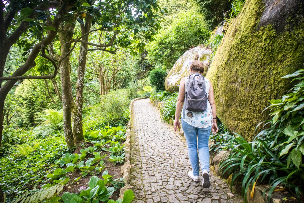 a girl walking the trail to pena place in sintra