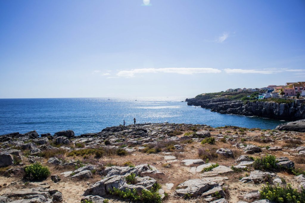 two people standing on a cliff in peniche 