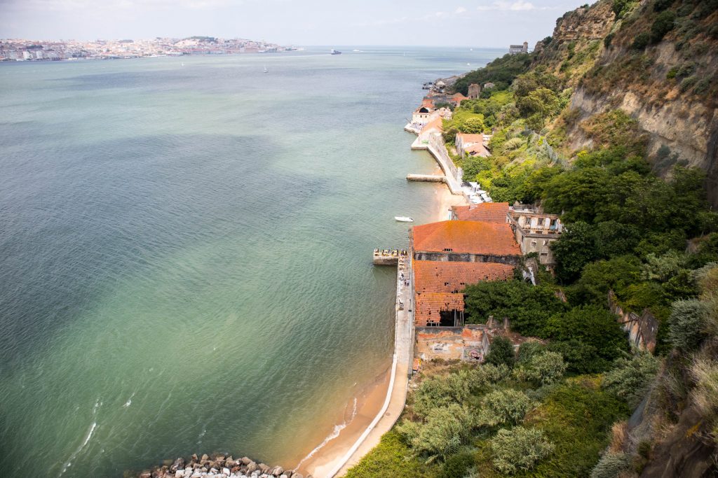 widok ze wzgorza w almadzie na domy, sciezke spacerowa i lizbone