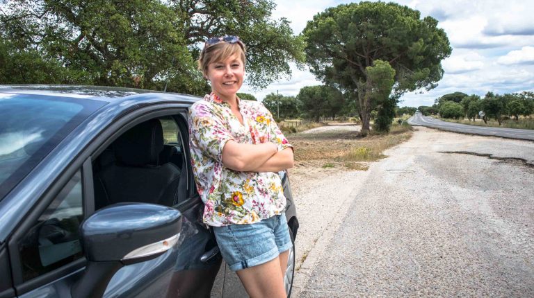 dziewczyna stoi obok samochodu na drodze w portugalii