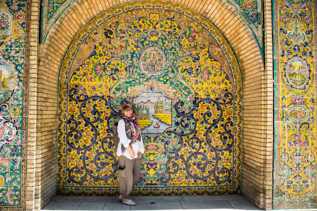 kobieta  w iranie stoi na tle kolorowej sciany