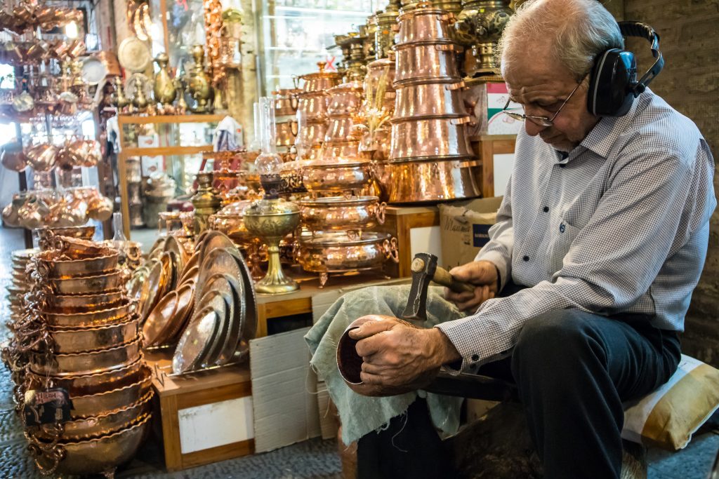 Mężczyzna produkujący garnki na bazarze w Esfahan, w Iranie.