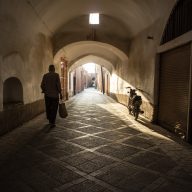 mężczyzna idzie wąską uliczką w yazd, w iranie.