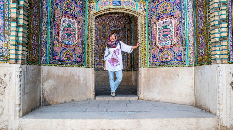 dziewczyna ubrana w hijab pozuje na tle kolorowej ściany w iranie