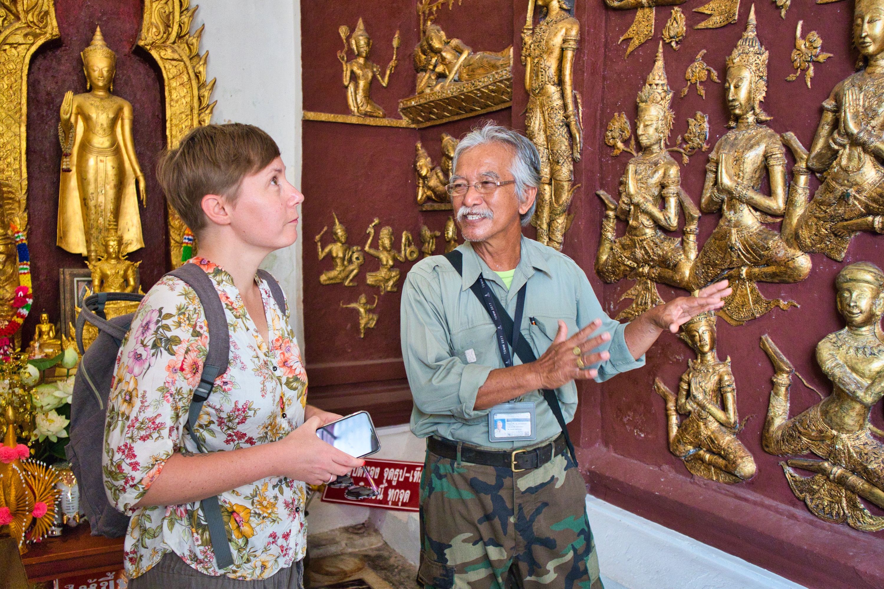 a Thai man showing a foreign woman a stucco in a temple in nakhon si thammarat
