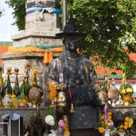 a sculpture of a king of thailand surrounded by colourful flowers in nakhon si thammarat