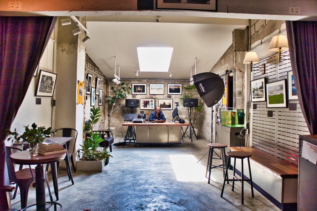 interior of a coffee shop in chiang mai with grey walls and photography equipment