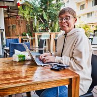 a digital nomad in chiang mai woman sitting at a wooden table in nimman social