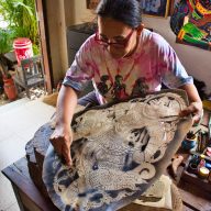 a woman shows how to make shadow puppets in nakhon si thammarat