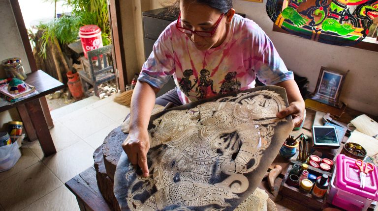 a woman shows how to make shadow puppets in nakhon si thammarat