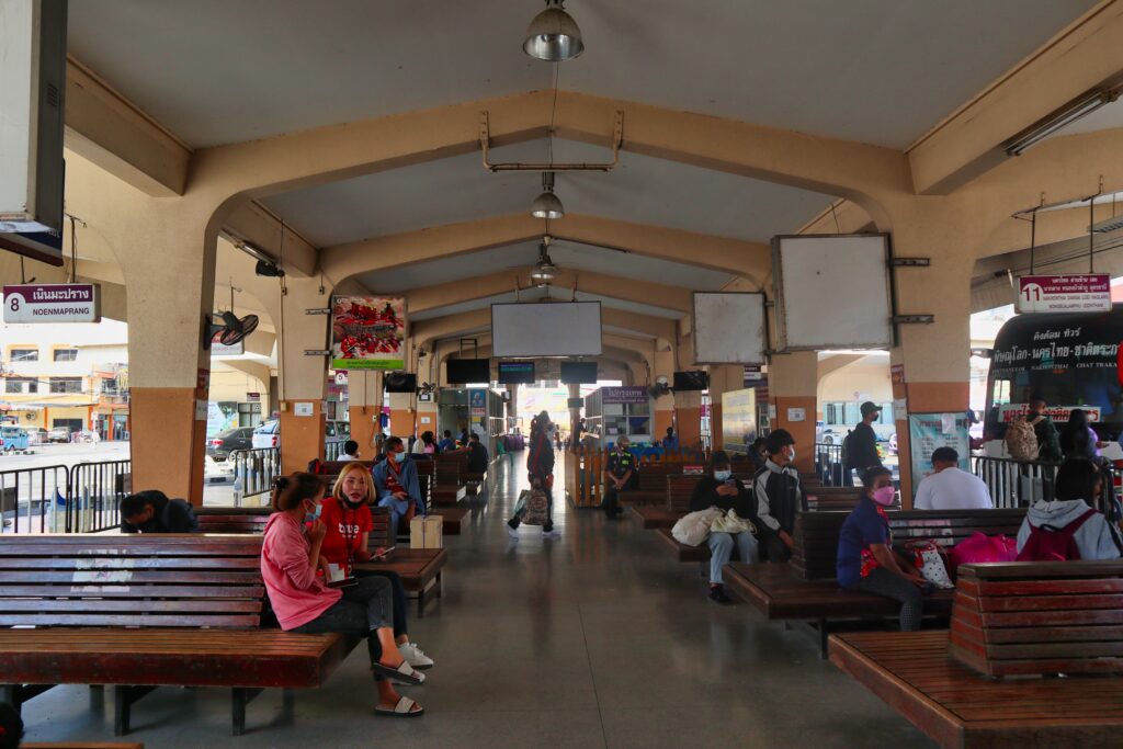 Ludzie siedzą na peronie stacji Phitsanulok w Tajlandii. 