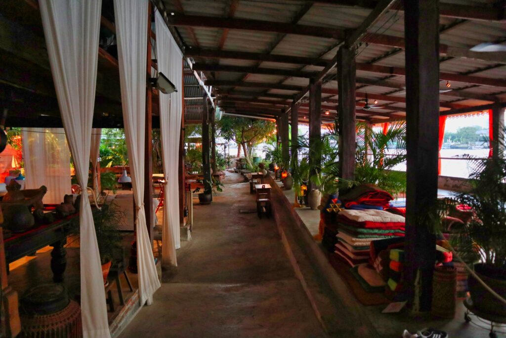 a riverview restaurant with tables facing the river in talad noi, bangkok.