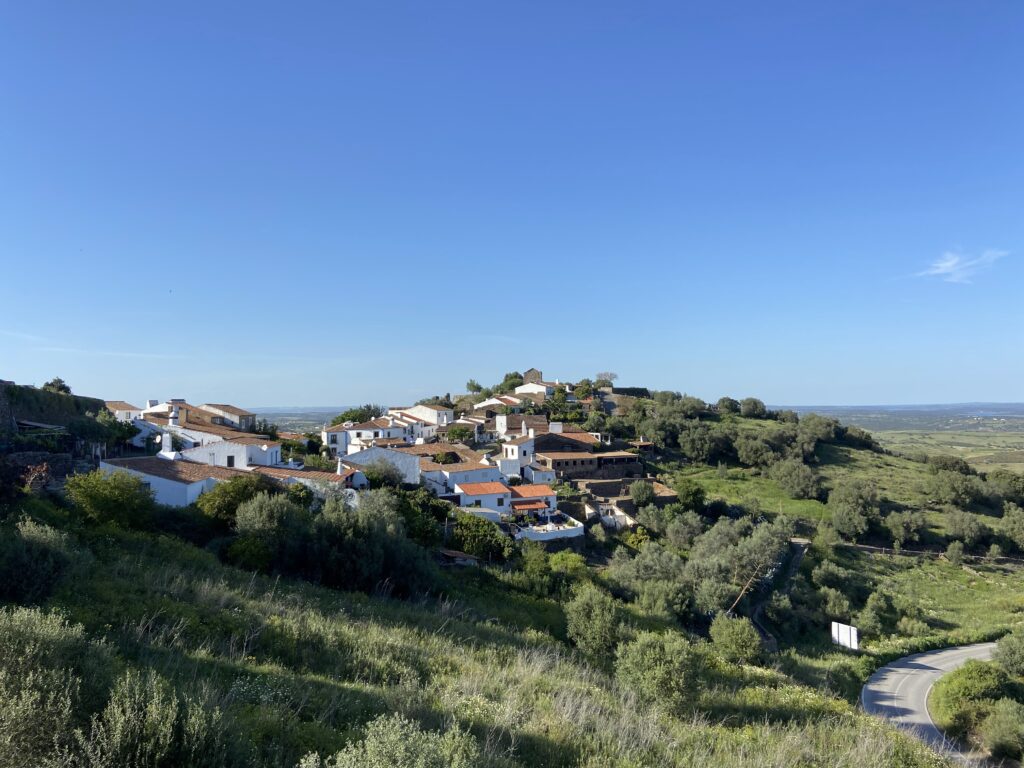 Co warto zobaczyć w Alentejo. Widok na małą wioskę z białymi domkami na szczycie wzgórza.