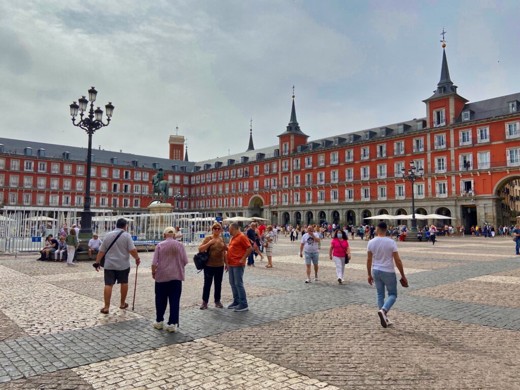 Turyści stoją na Placu Mayor w Madrycie.