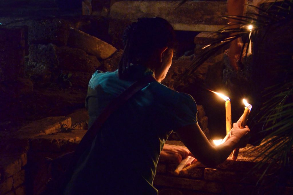 Woman burning a candle during Makha Bukha